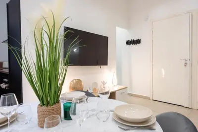 a dining room with a table with glasses and a plant at Renovated Apartment in the Heart of Cannes in Cannes