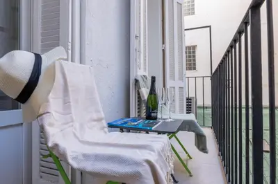 a balcony with a table and a chair on a balcony at Renovated Apartment in the Heart of Cannes in Cannes