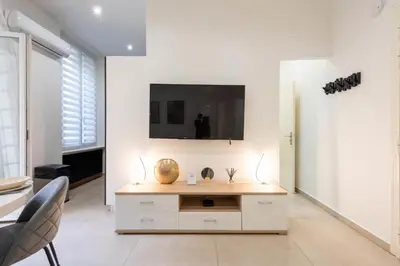 a living room with a tv on a white wall at Renovated Apartment in the Heart of Cannes in Cannes