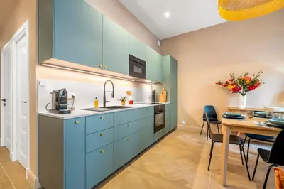 a kitchen with blue cabinets and a dining table at L'Urban - 3 chambres - 9 min Palais - Climatisé in Cannes