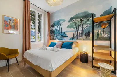 a bedroom with a bed with a painting on the wall at L'Urban - 3 chambres - 9 min Palais - Climatisé in Cannes