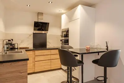 a kitchen with a sink and a table with chairs at Plage luxe collé à l’hôtel Martinez in Cannes