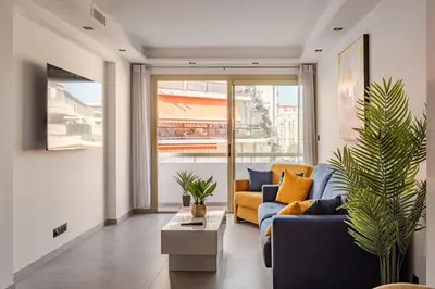 a living room with a blue couch and a yellow chair at Plage luxe collé à l’hôtel Martinez in Cannes