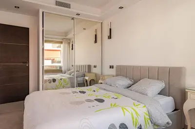a bedroom with a large bed and a mirror at Plage luxe collé à l’hôtel Martinez in Cannes