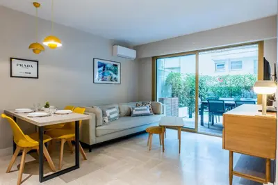 a living room with a couch and a table at Downtown Cannes Apartment with Garden in Cannes