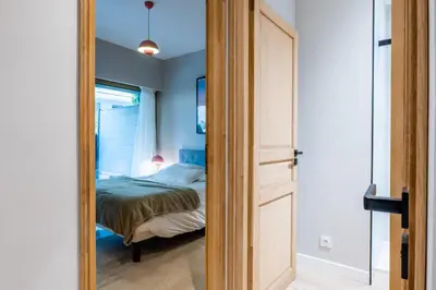 a door leading to a bedroom with a bed at Downtown Cannes Apartment with Garden in Cannes