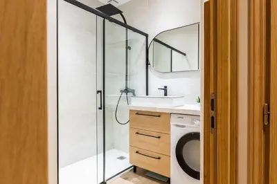a bathroom with a shower and a washing machine at Downtown Cannes Apartment with Garden in Cannes