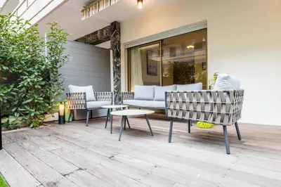 a patio with two chairs and a couch and a table at Downtown Cannes Apartment with Garden in Cannes