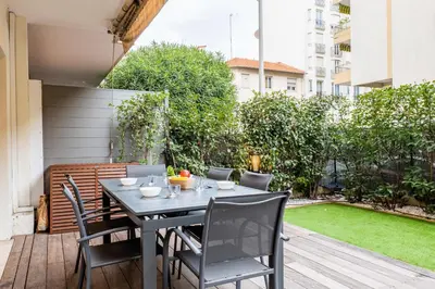a patio with a table and chairs on a deck at Downtown Cannes Apartment with Garden in Cannes