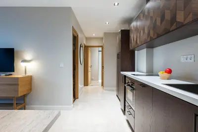 a kitchen with wooden cabinets and a counter top at Downtown Cannes Apartment with Garden in Cannes