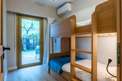 a bedroom with bunk beds and a sliding glass door at Downtown Cannes Apartment with Garden in Cannes