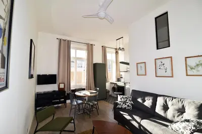 a living room with a couch and a table at Charming studio very central and calm in Cannes