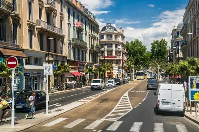a busy city street with cars parked on the road at Charming studio very central and calm in Cannes