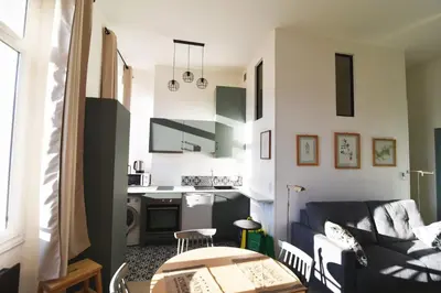 a living room with a couch and a kitchen at Charming studio very central and calm in Cannes
