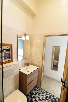 a bathroom with a sink and a mirror at Charming studio very central and calm in Cannes