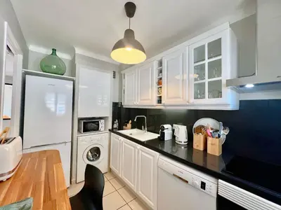 a kitchen with white cabinets and a black counter top at Savannah appartement proche Carlton, by Welcome to Cannes in Cannes