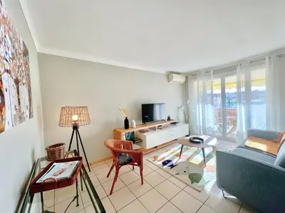 a living room with a blue couch and a tv at Savannah appartement proche Carlton, by Welcome to Cannes in Cannes