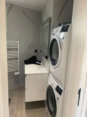 a bathroom with a washing machine and a sink at Appartement MARTINEZ 5 couchages in Cannes