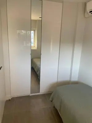a bedroom with a glass door leading to a bed at Appartement MARTINEZ 5 couchages in Cannes