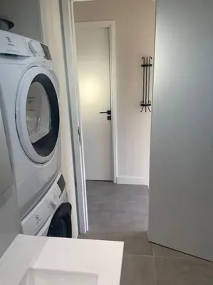 a washing machine in a room with a door at Appartement MARTINEZ 5 couchages in Cannes