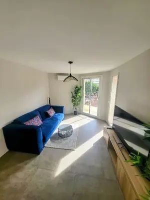 a living room with a blue couch and a window at Appartement MARTINEZ 5 couchages in Cannes