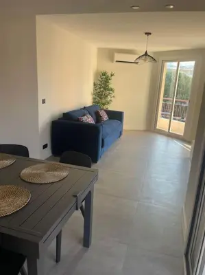 a living room with a blue couch and a table at Appartement MARTINEZ 5 couchages in Cannes