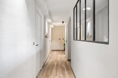 a hallway with white walls and wood floors and a mirror at Jessicannes - COOPER - 3 chambres - Central, spacieux, terrasse in Cannes