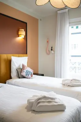 two beds in a hotel room with towels on the beds at Jessicannes - COOPER - 3 chambres - Central, spacieux, terrasse in Cannes