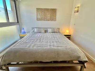 a large bed in a room with two tables at Mimosas by Welcome to Cannes in Cannes