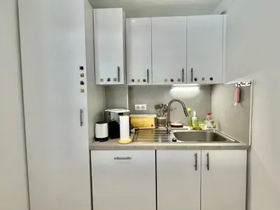 a kitchen with white cabinets and a sink at Mimosas by Welcome to Cannes in Cannes