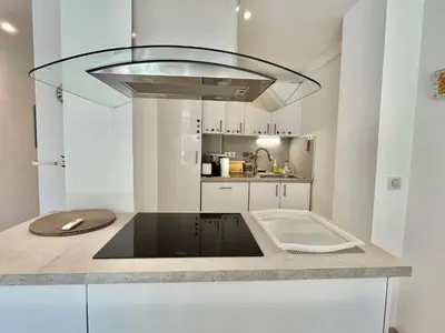a kitchen with white cabinets and a glass hood at Mimosas by Welcome to Cannes in Cannes