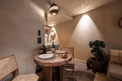 a dining room with a wooden table and chairs at WABISABI SUITES - MÉRO in Cannes