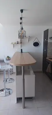 a kitchen with a wooden table in a room at Ciel Bleu de Cannes - Appartement Vue Azur avec Piscines et Jardin in Cannes