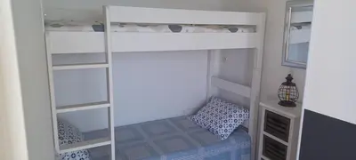 a bedroom with a bunk bed with a chair in it at Ciel Bleu de Cannes - Appartement Vue Azur avec Piscines et Jardin in Cannes