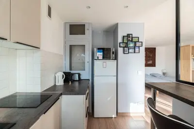 a kitchen with a white refrigerator in a room at 3 VIDAL - Splendide appartement 4 couchage hyper centre de Cannes in Cannes