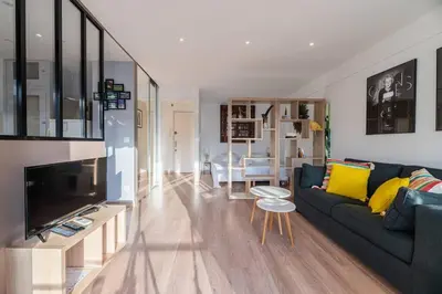 a living room with a blue couch and a tv at 3 VIDAL - Splendide appartement 4 couchage hyper centre de Cannes in Cannes
