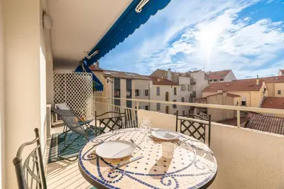 a table on a balcony with a view of a city at 3 VIDAL - Splendide appartement 4 couchage hyper centre de Cannes in Cannes