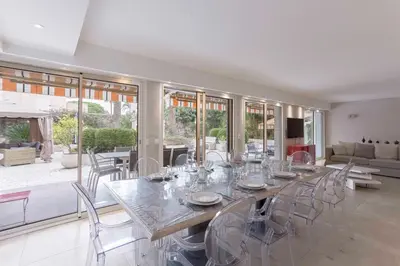 a dining room with a long table and chairs at Jardin d'Azur – Terrace, Calm & Croisette in Cannes
