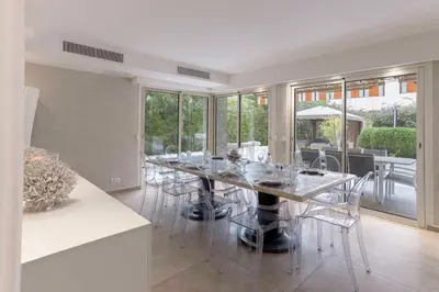 a dining room with a long table and chairs at Jardin d'Azur – Terrace, Calm & Croisette in Cannes