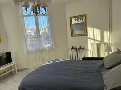 a bedroom with a blue bed and a television at Studio 6minutes Croisette cannes in Cannes