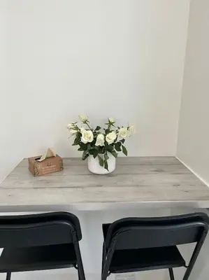 a table with a vase of flowers and two chairs at Studio 6minutes Croisette cannes in Cannes