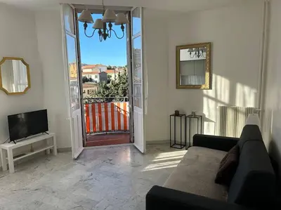 a living room with a couch and a door to a balcony at Studio 6minutes Croisette cannes in Cannes