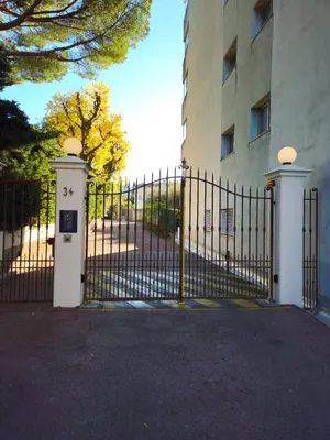 a black fence with a gate in front of a building at Charmant studio centre de Cannes in Cannes