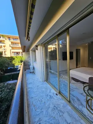 a room with a balcony with a bed and windows at Charmant studio centre de Cannes in Cannes
