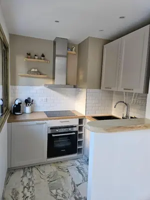 a kitchen with white cabinets and a black oven at Charmant studio centre de Cannes in Cannes