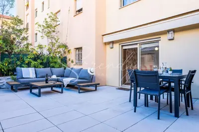 a patio with a couch and a table and chairs at RARE ! Studio with terrace 5min walk to the Palais in Cannes
