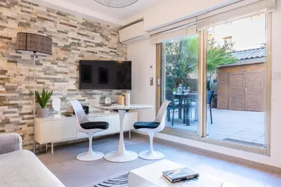 a living room with a table and chairs and a tv at RARE ! Studio with terrace 5min walk to the Palais in Cannes