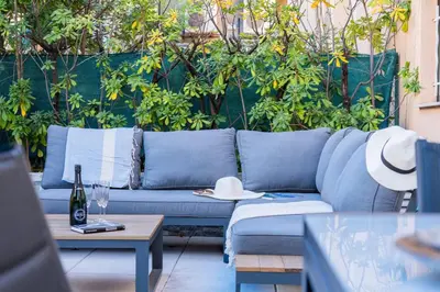 a blue couch in a patio with plants at RARE ! Studio with terrace 5min walk to the Palais in Cannes