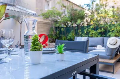 a table with a glass vase and two plants on it at RARE ! Studio with terrace 5min walk to the Palais in Cannes