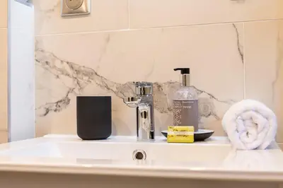 a bathroom sink with a soap dispenser and a towel at RARE ! Studio with terrace 5min walk to the Palais in Cannes